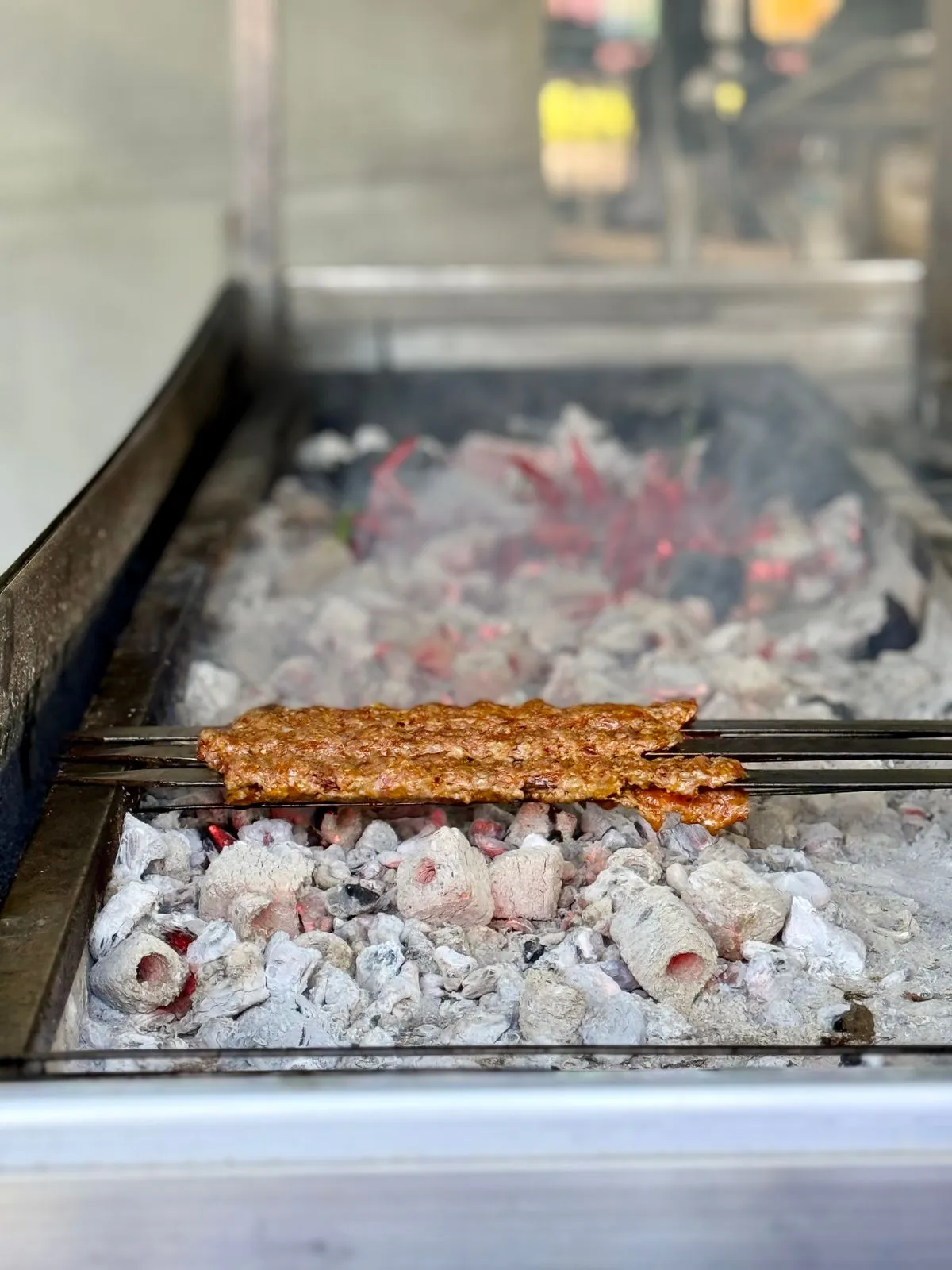 Minced-meat kebabs grilling over coals