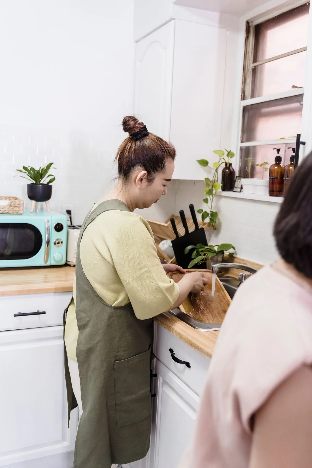 Washing a chopping board at a sink