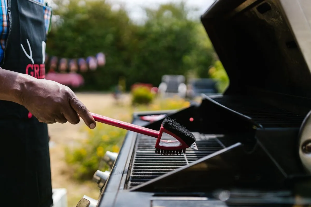 A barbecue grate being cleaned