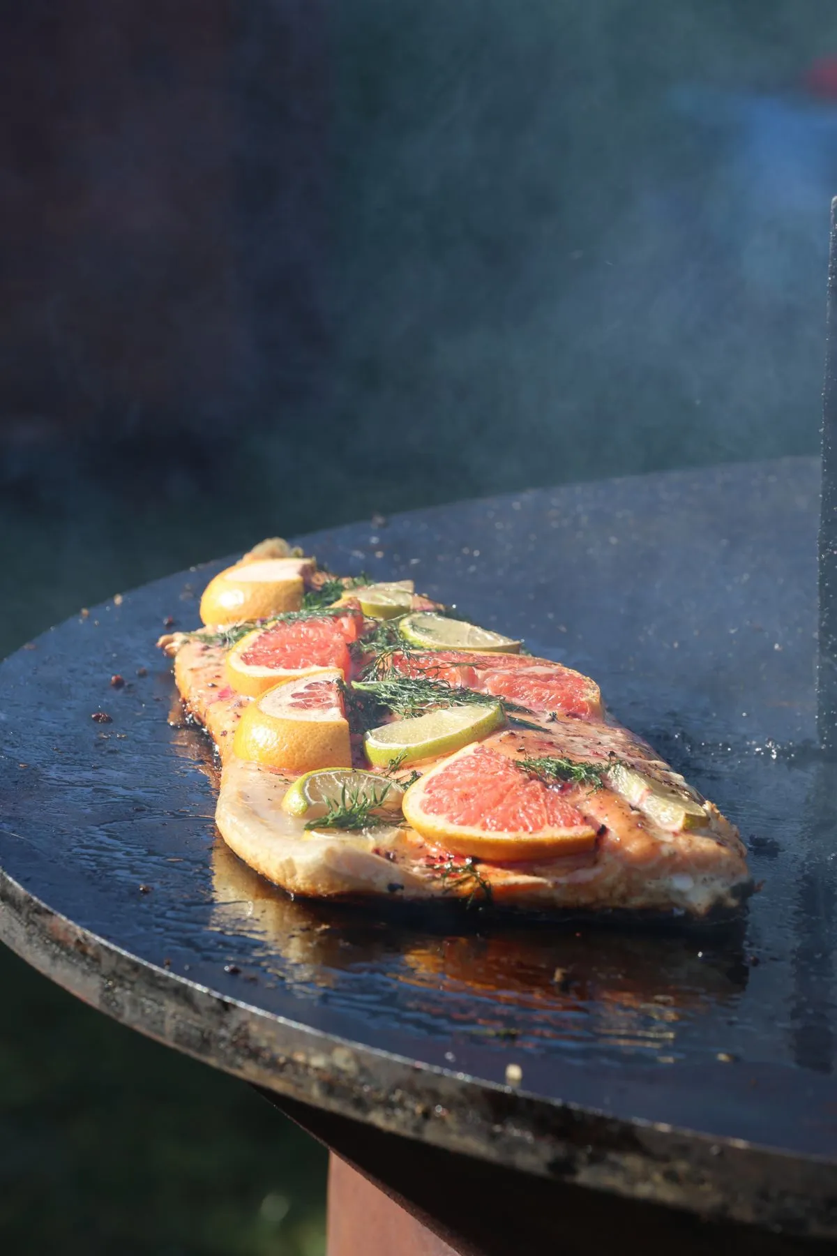 Salmon and citrus cooking on an outdoor grill
