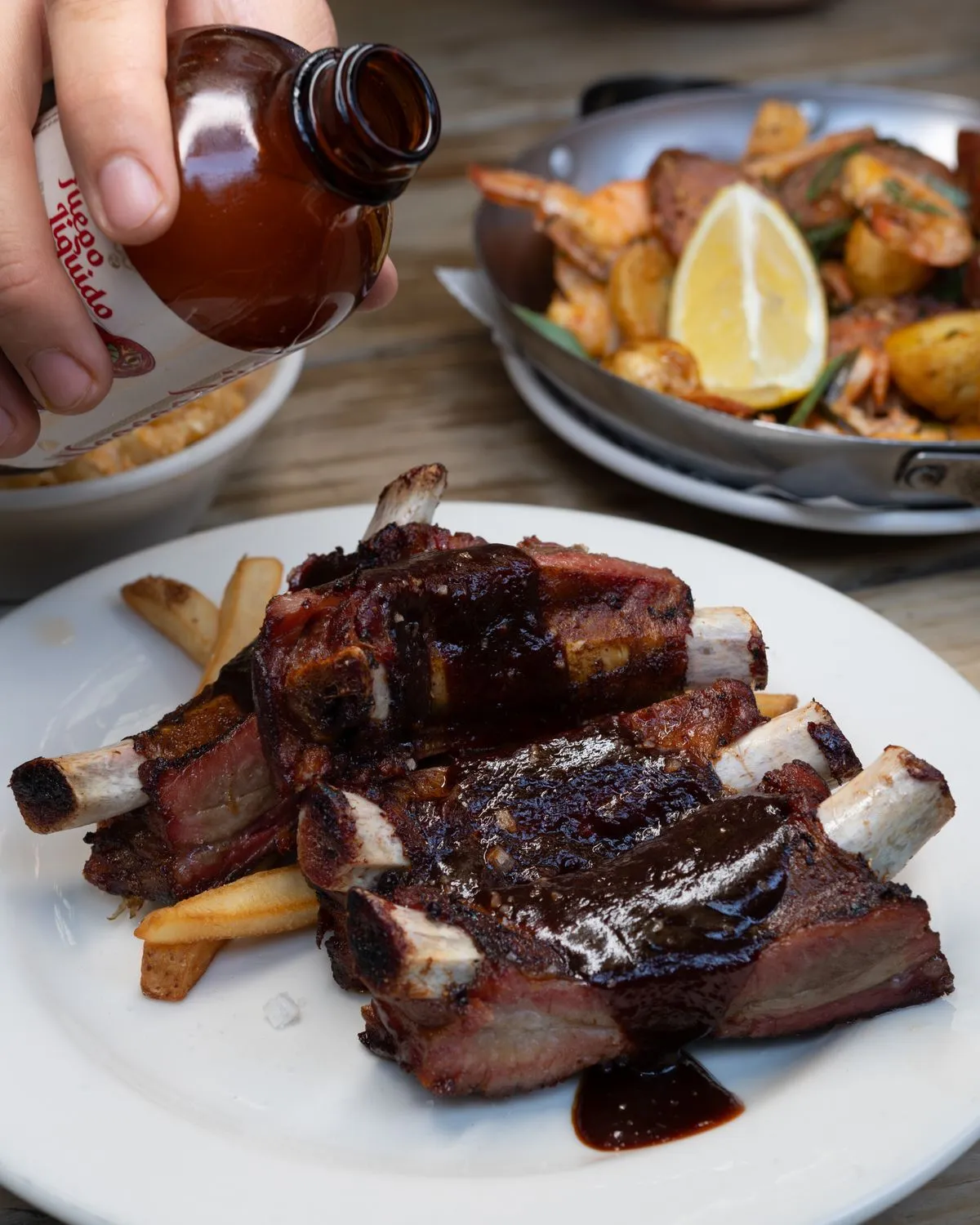 Barbecue sauce being poured over ribs