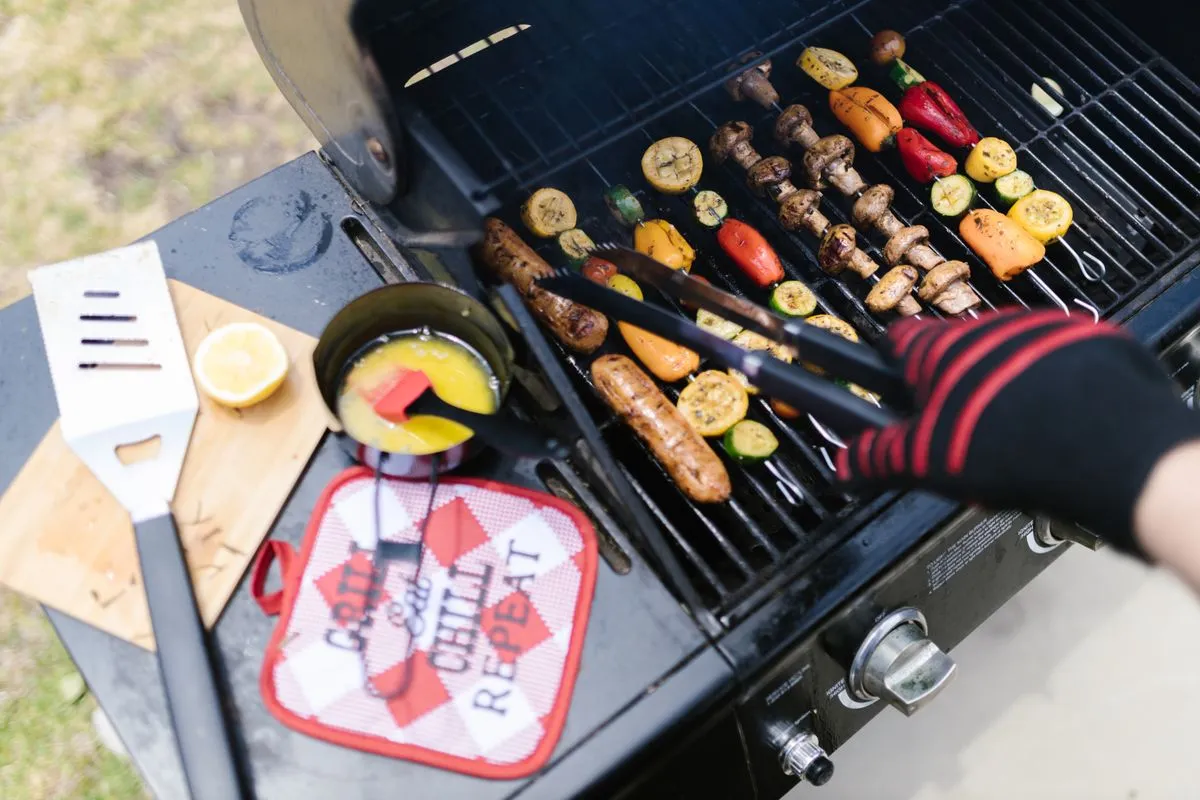 A cook using protective gloves at the grill