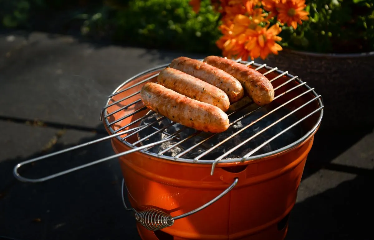 A small charcoal grill with sausages