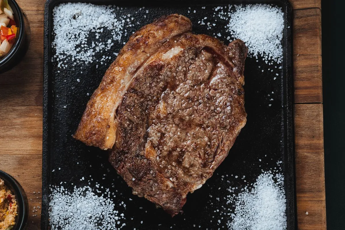 Grilled ribeye on a dark cutting board