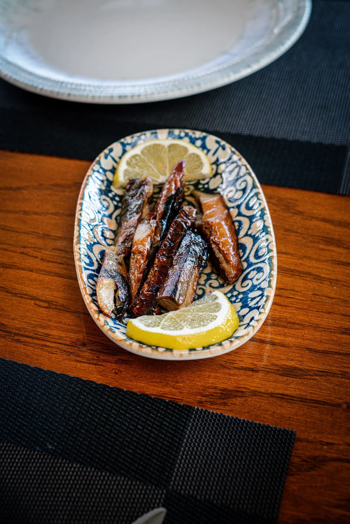Sardines with lemon on a ceramic plate