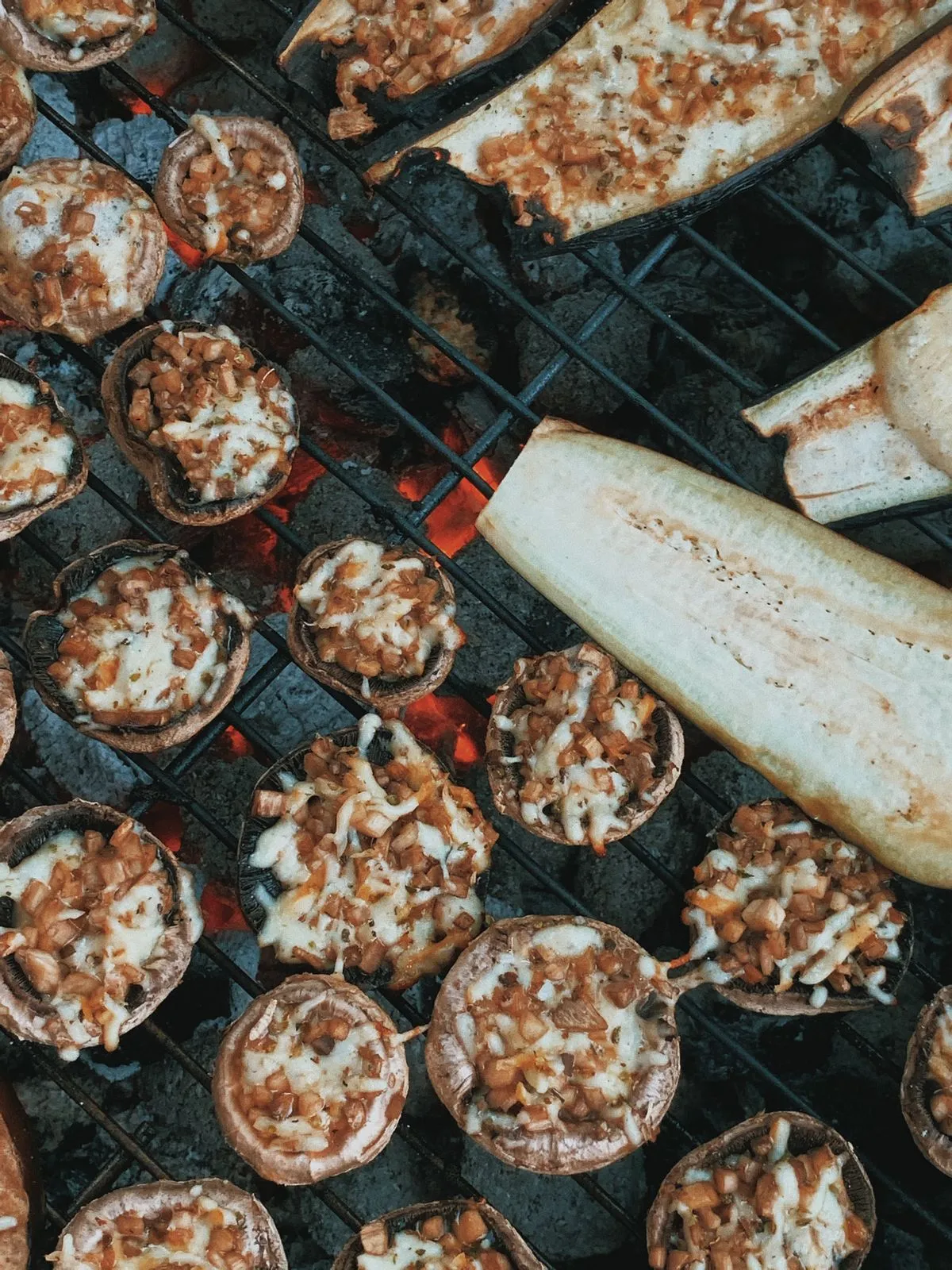Stuffed mushrooms cooking beside eggplant